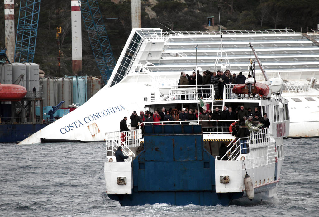 Los restos del barco, propiedad de la naviera Costa Cruceros, siguen encallados frente a la isla rodeados de gigantes estructuras de metal para permitir una remoción que se ha retrasado los últimos meses. Foto/AP<br>