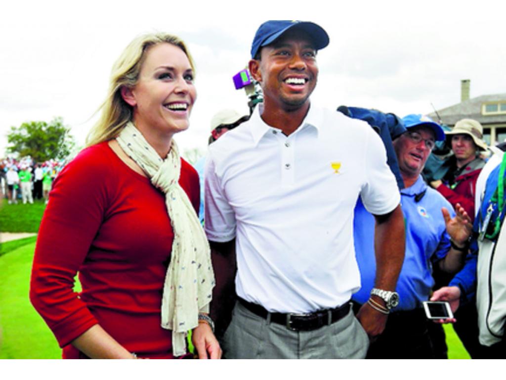 Lindsey Vonn sonríe junto a su novio Tiger Woods, tras la victoria del conjunto estadounidense ayer en el campo de Muirfield.(Foto: AP)