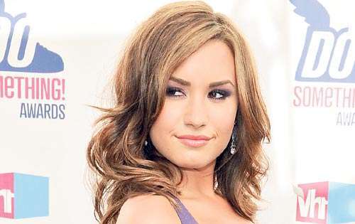 <p>Demi Lovato mezcló naranja, morado y el negro en este minivestido con tiras. </p>