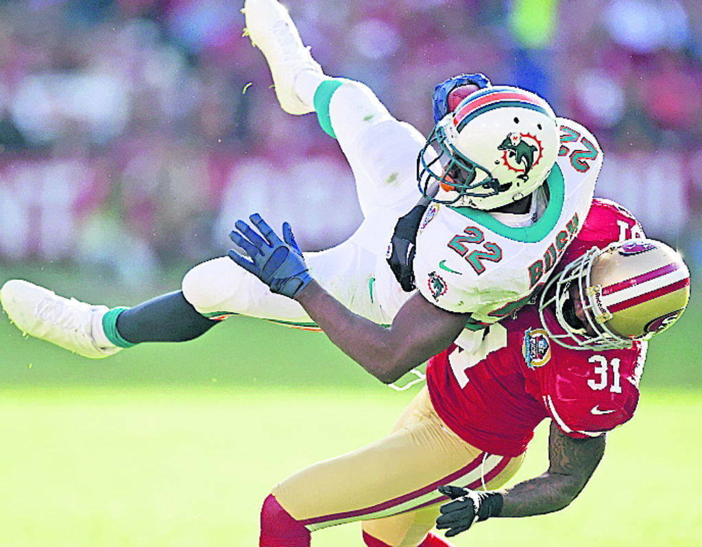 Figura. Reggie Bush (22) es atacado por Donte Whitner.(AP)