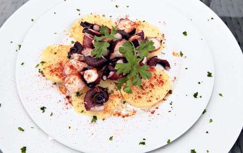 <p>Papas asadas, con pequeños trozos de pulpos salteados con una salsa secreta.</p>