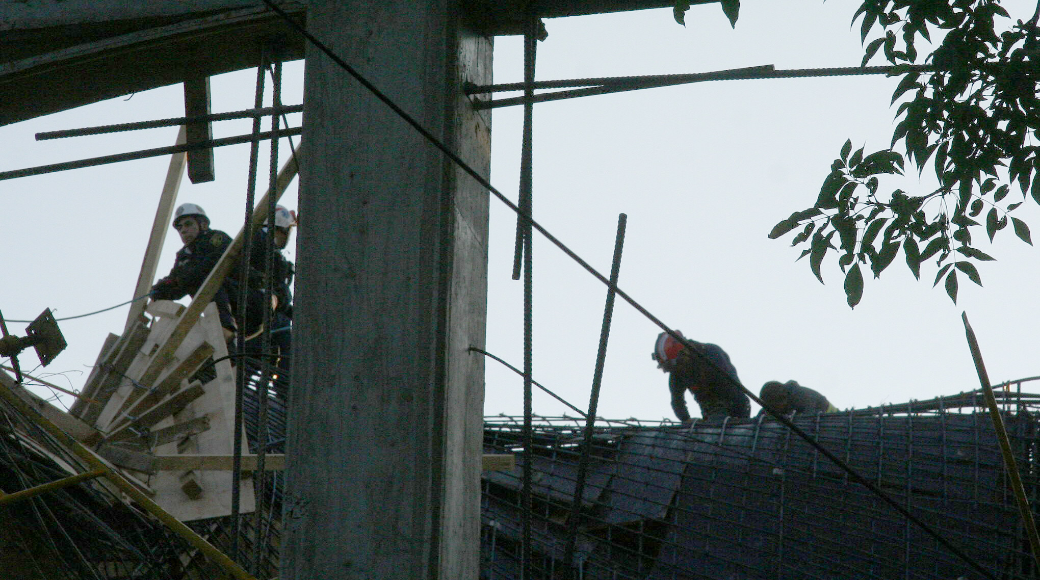 Trabajadores intentan bajar de entre las varillas de acero colapsadas. Foto/EFE
