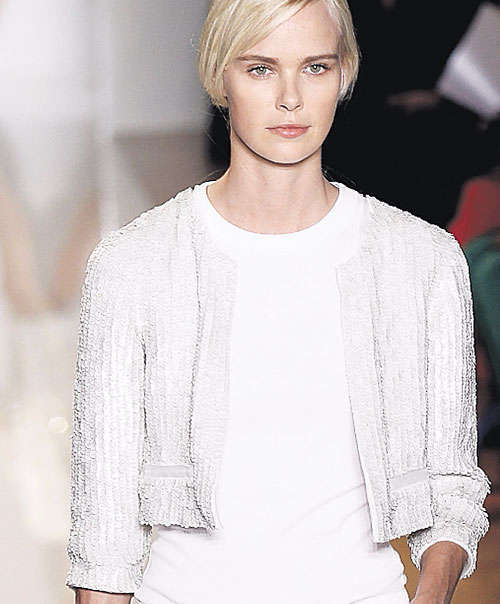 <p>Casual. Skinny jeans con suéter blanco y un chaleco de brillantes en tono gris. La cartera, también blanca, es un accesorio esencial en esta colección.</p>