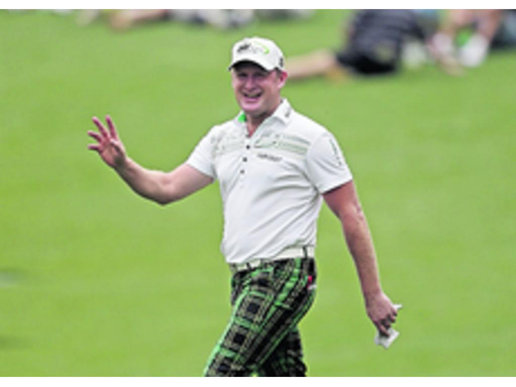 El jugador aficionado Guan Tianlang levanta la mano en señal de satisfacción, después de terminar el primer recorrido.( Foto: AP)