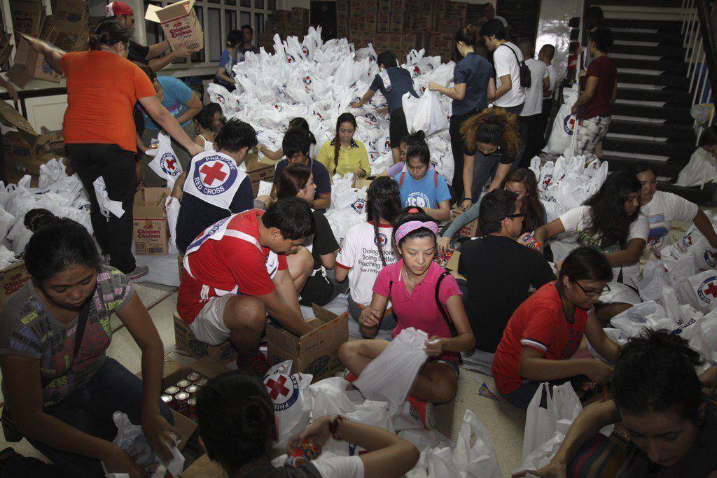 La Cruz Roja Filipina que muestra a voluntarios empaquetando material de ayuda humanitaria para los damnificados por el tifón Haiyan. Foto/EFE<br>