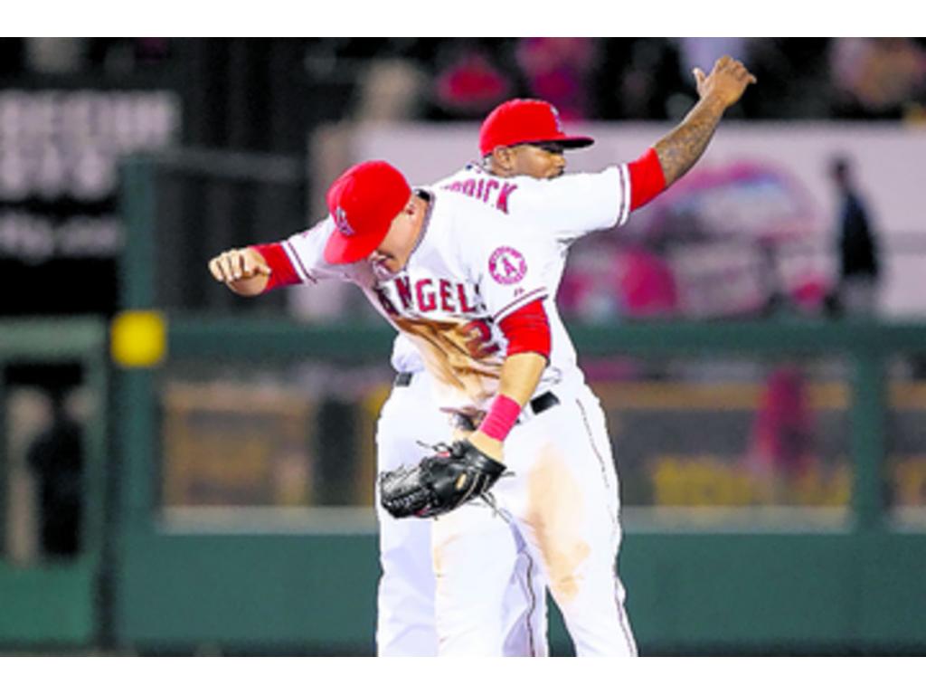 Mike Trout celebra con su compañero Howie Kendrick la victoria de los Angelinos, 12 por 0, sobre los Marineros. En este partido bateó de 5-4, anotó dos carreras y empujó cinco, para ser la bujía del equipo.