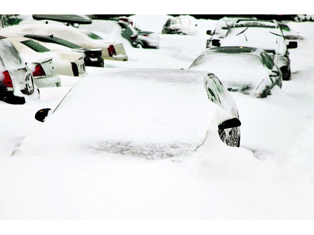 Decenas de carros quedaron cubiertos por la nieve.(AP)