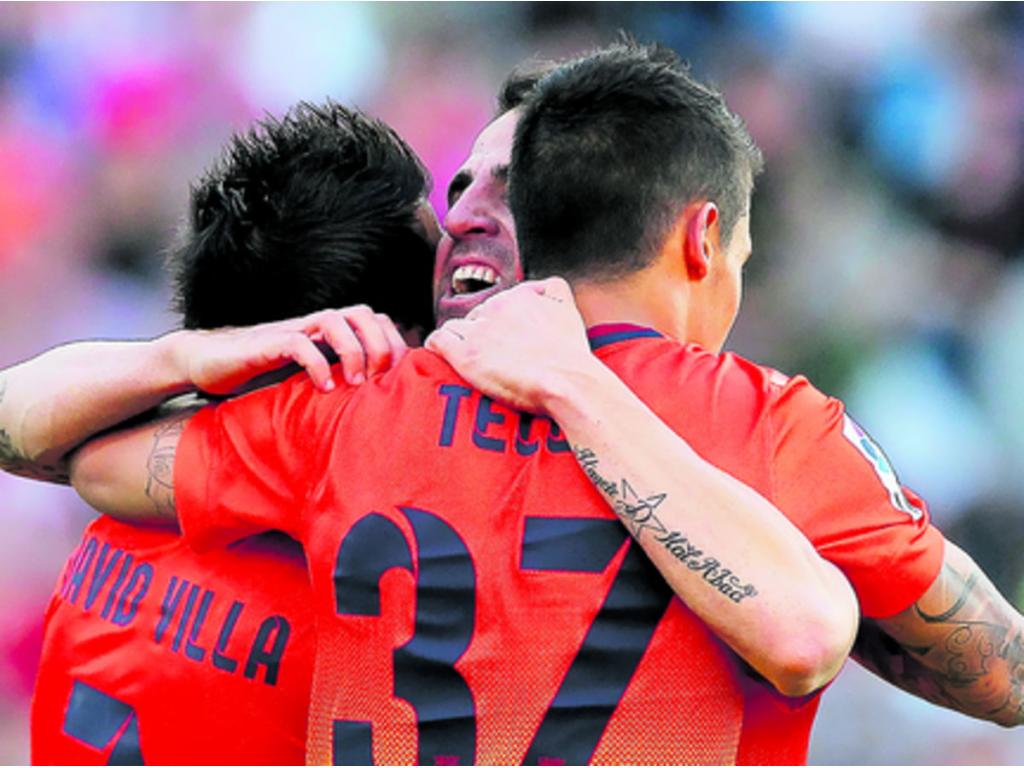 David Villa (izq.), Cesc Fabregas (c) y Cristian Tello (dcha.) festejan el autogol que les dio el triunfo ayer sobre el Atlético Madrid.(AP)