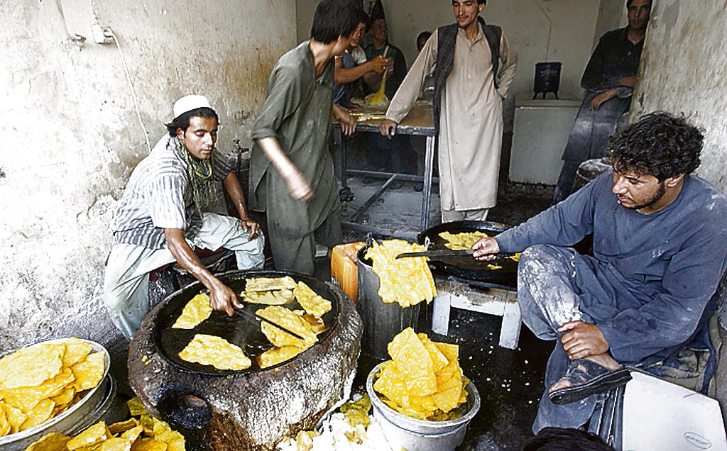 Grupo. Hombres preparan una comida tradicional.(EFE)