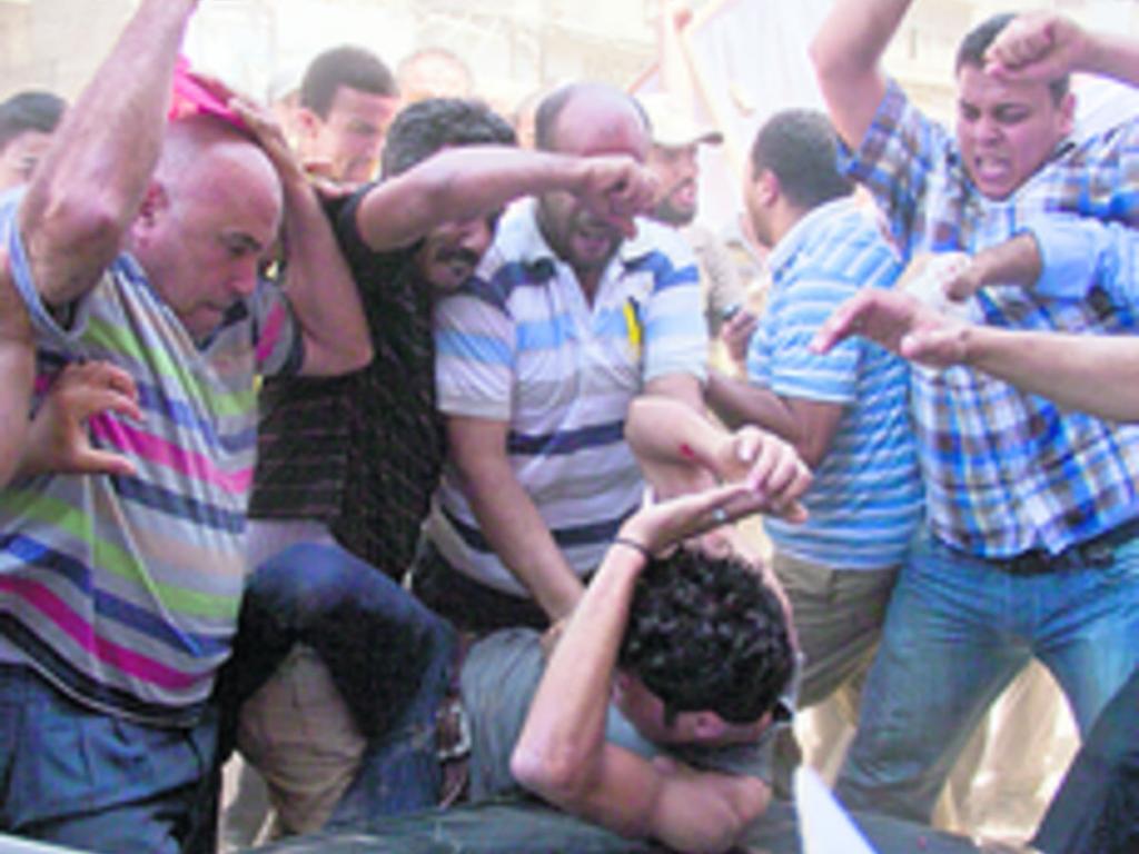 Seguidores del derrocado presidente Mursi golpean a un opositor.(AP)