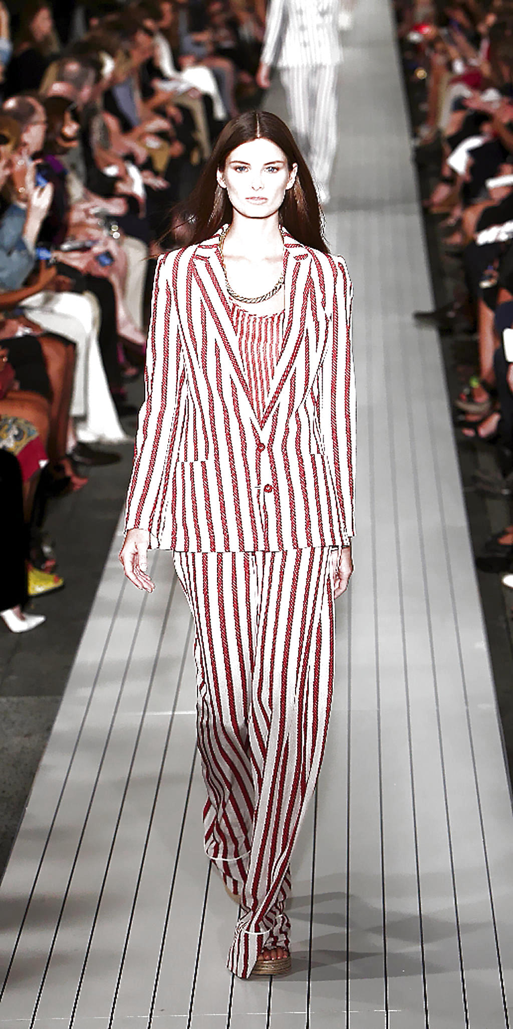 Conjunto con rayas. Un juego de pantalón, chaqueta y blusa en tonos blancos con rayas rojas. Para acompañar se apuesta por una elegante cadena dorada.()