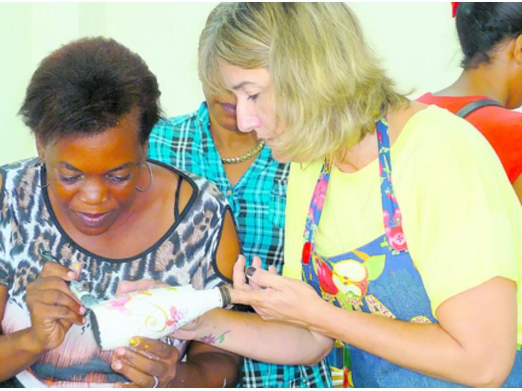 Orgullosas, ellas muestran sus trabajos de arte terminados.