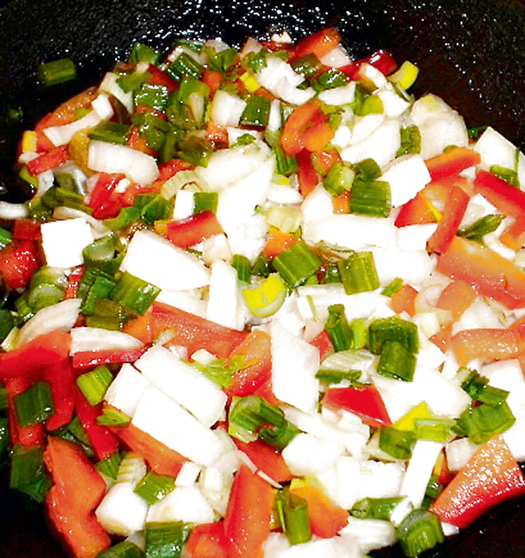 Agregue a las cebollas el orégano, salvia, ajíes y ajos, y cocine durante 3 minutos.()