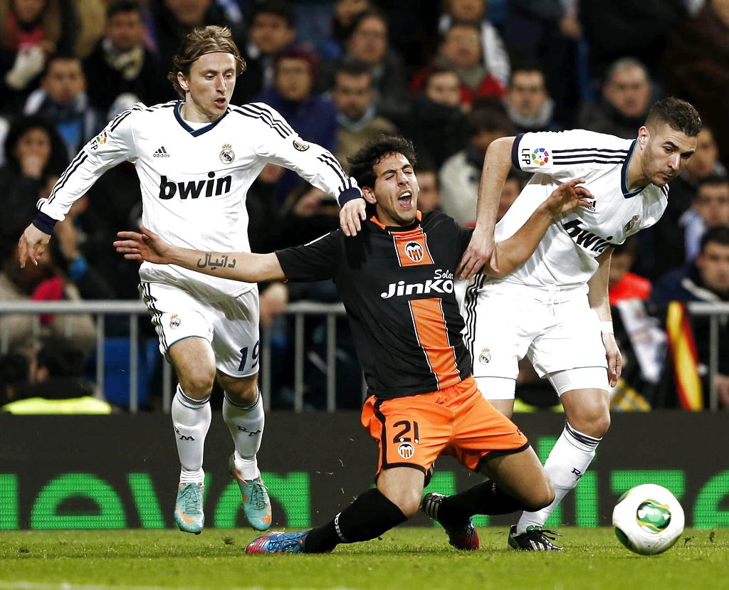El centrocampista croata del Real Madrid Luka Modric (i) y su compañero, el defensa francés Karim Benzema (d), disputan el balón con el centrocampista del Valencia Dani Parejo (c). EFE<br>