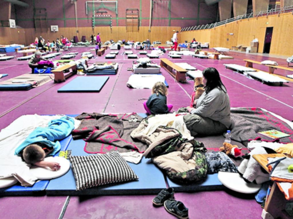 2- Personas permanecen en un gimnasio convertido en refugio para damnificados.