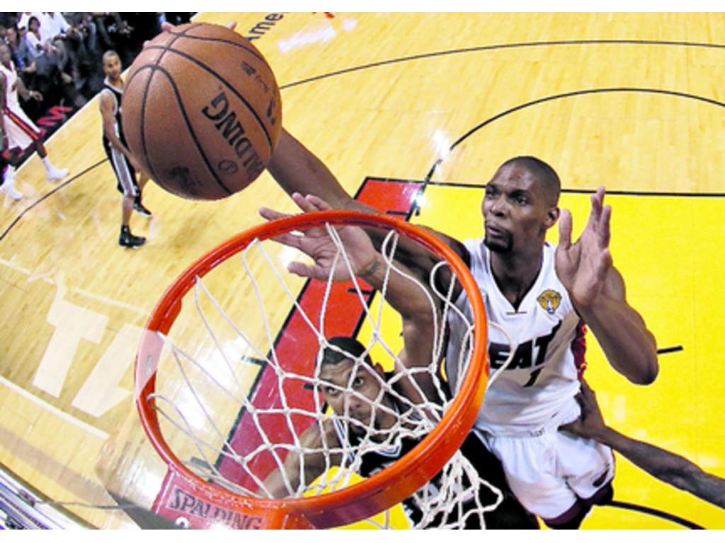 Chris Bosh (dcha.) sacó a relucir su defensa en el último cuarto del partido y en el tiempo extra cuando ya expiraba, tapando un intento de triple de Danny Green desde la esquina. (EFE)