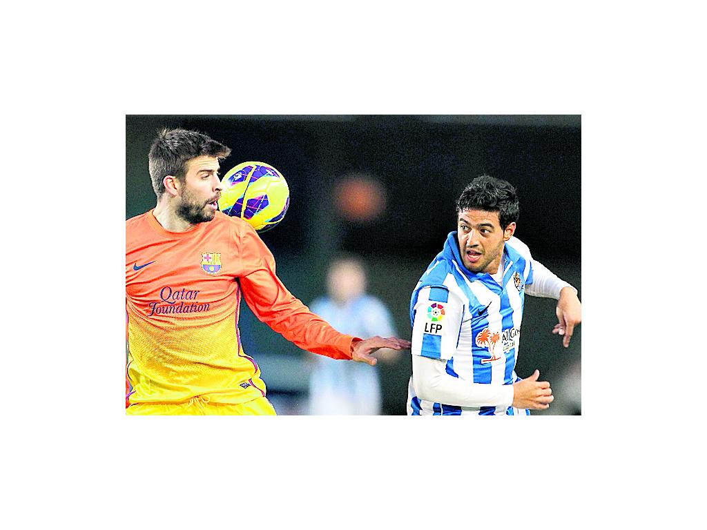 Juego. Gerard Piqué (i) encara a Carlos Vela.(EFE)