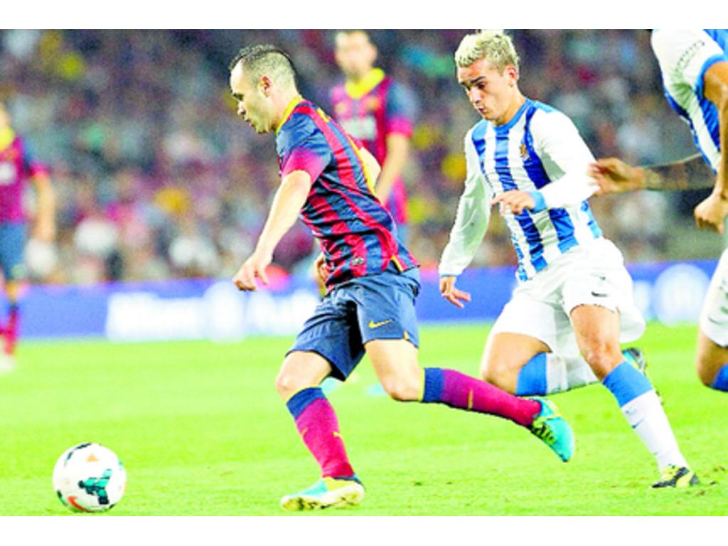 Iniesta (izq.) controla el balón seguido por Antoine Griezmann.(EFE)