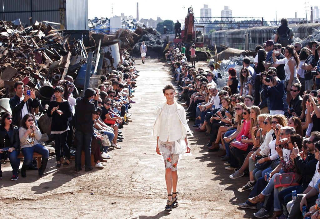 Una modelo camina sobre la pasarela poco inusual, donde montañas de chatarra decoraron el evento. Foto/AP<br>