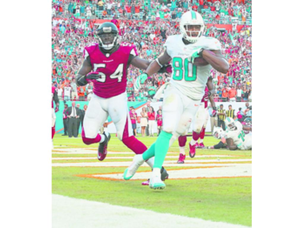 Dion Sims (80), de Miami, escapa de su marcador.(AP)