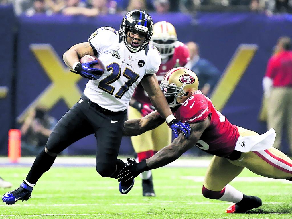 El running back de los Ravens, Ray Rice (27), trata de escapar de la defensa del linebacker de los 49ers, Aldon Smith (99).()