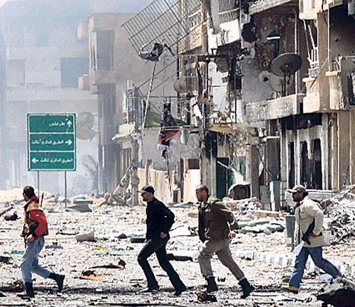 <p>Rebeldes atraviesan una calle de Misrata.</p>