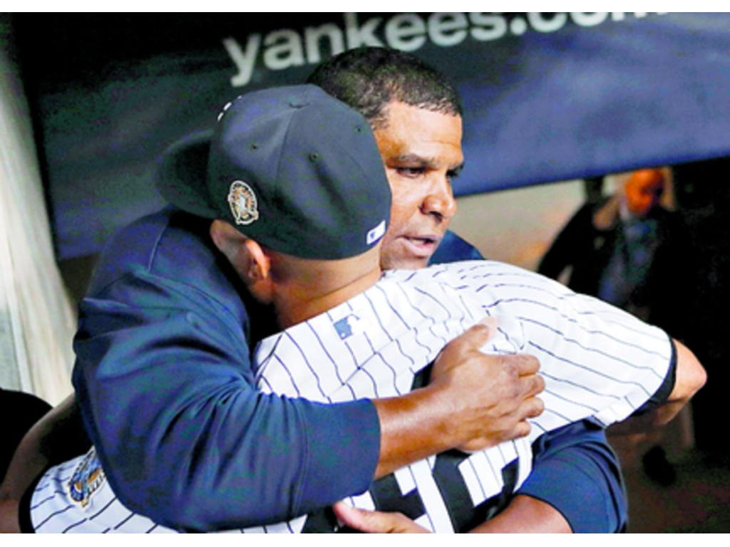 Mike Harkey, coach de bullpen de los Bombarderos del Bronx, abraza a Mo en su despedida definitiva del Yankee Stadium.(Foto: AP)
