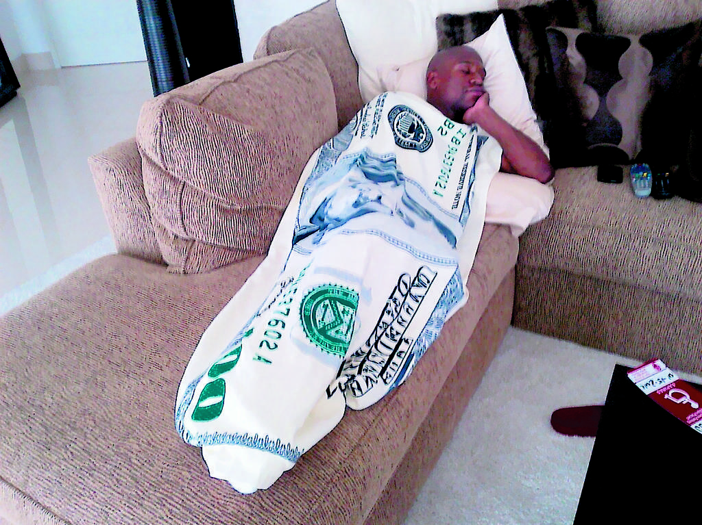 Curiosidad. Floyd arropado con una manta que tiene la imagen del dólar americano.(AP)