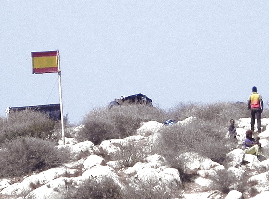 Vista de 4 de los 81 inmigrantes que permanecen en la Isla de Tierra, de soberanía española, llegados en dos grupos la semana pasada a esta isla. Foto/EFE<br>