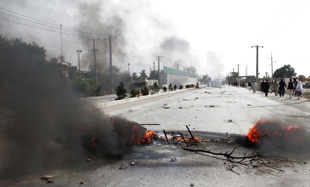 Un humo espeso enrarecía el aire en la calle Jalalabad una importante vía hacia el centro de la ciudad donde la multitud quemaba contenedores y neumáticos. Foto/AP<br>