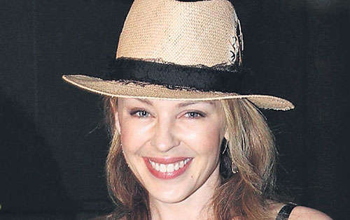 <p>Kylie Minogue lució informal y fresca con este vestido con recogidos y botones al frente. El toque diferente se lo ofrece el sombrero de rafia con encajes. </p>