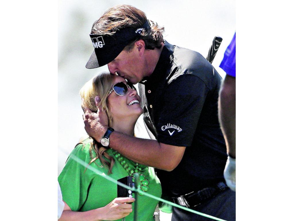 Phil Mickelson besa a su esposa Amy, luego de terminar su práctica.(AP)