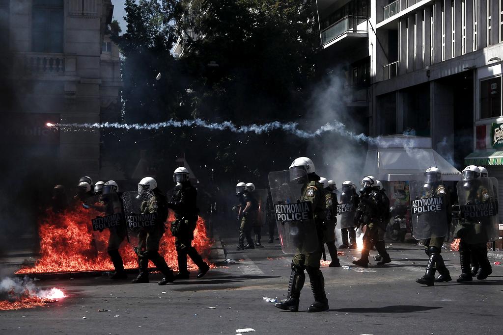 Policías antidisturbios avanzan entre focos de llamas durante los choques violentos entre manifestantes y las fuerzas de seguridad ocurridos. Foto/EFE