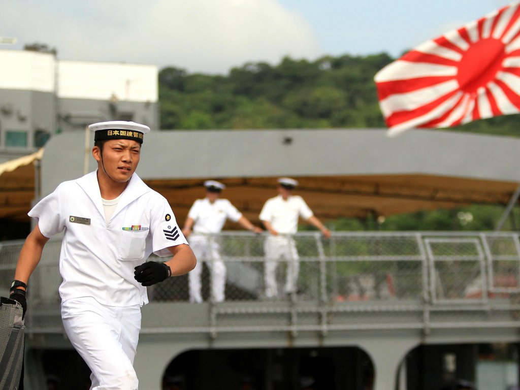 Un marino japonés corre frente a un buque de la escuadra de entrenamiento de Japón. Foto/EFE<br>
