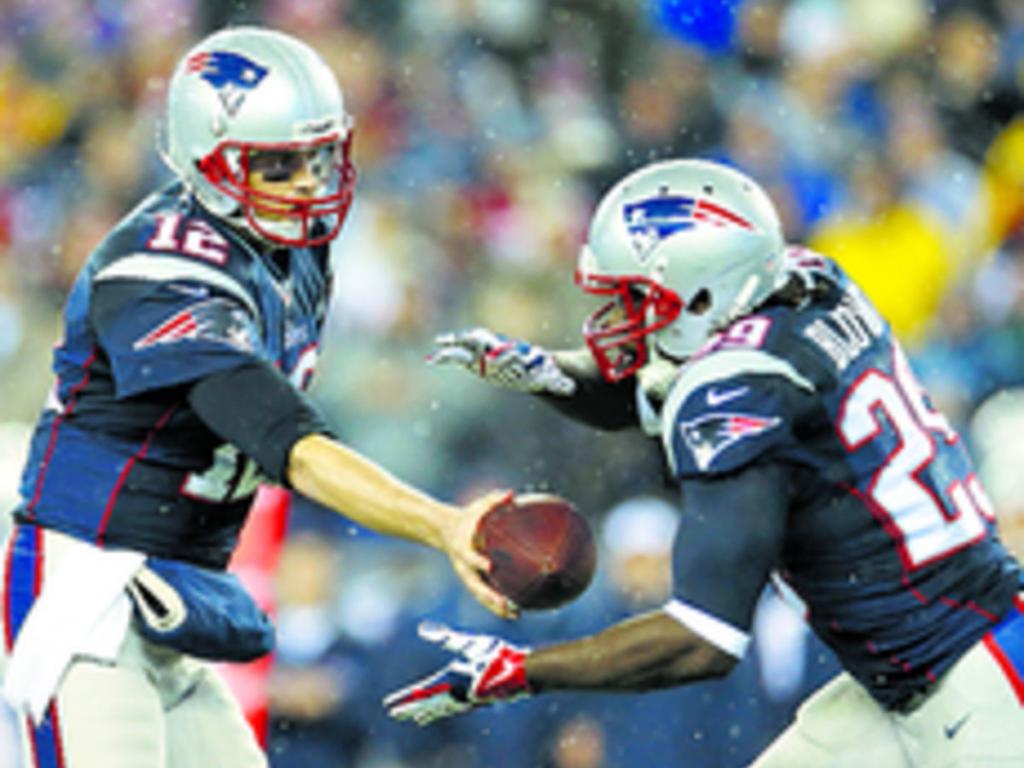 Brady (izq.) le entrega el ovoide a su compañero LeGarrette Blount.(AP)