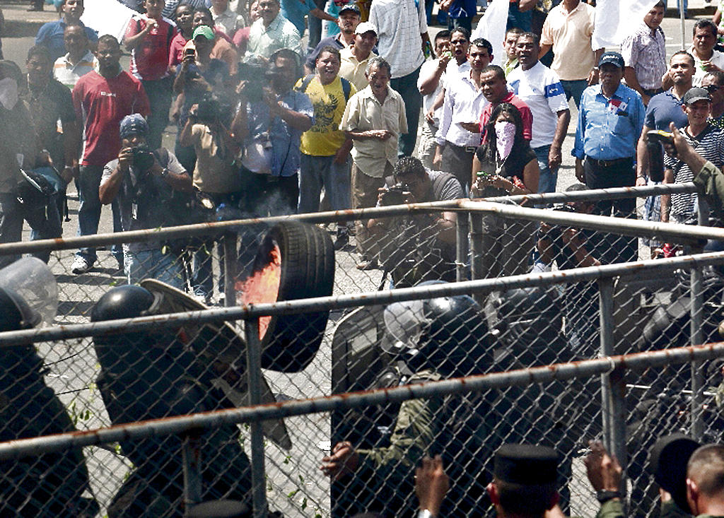 Disturbios. Manifestantes tiran una llanta en llamas a los antimotines, que respondieron con gases lacrimógenos.(Víctor Arosemena)
