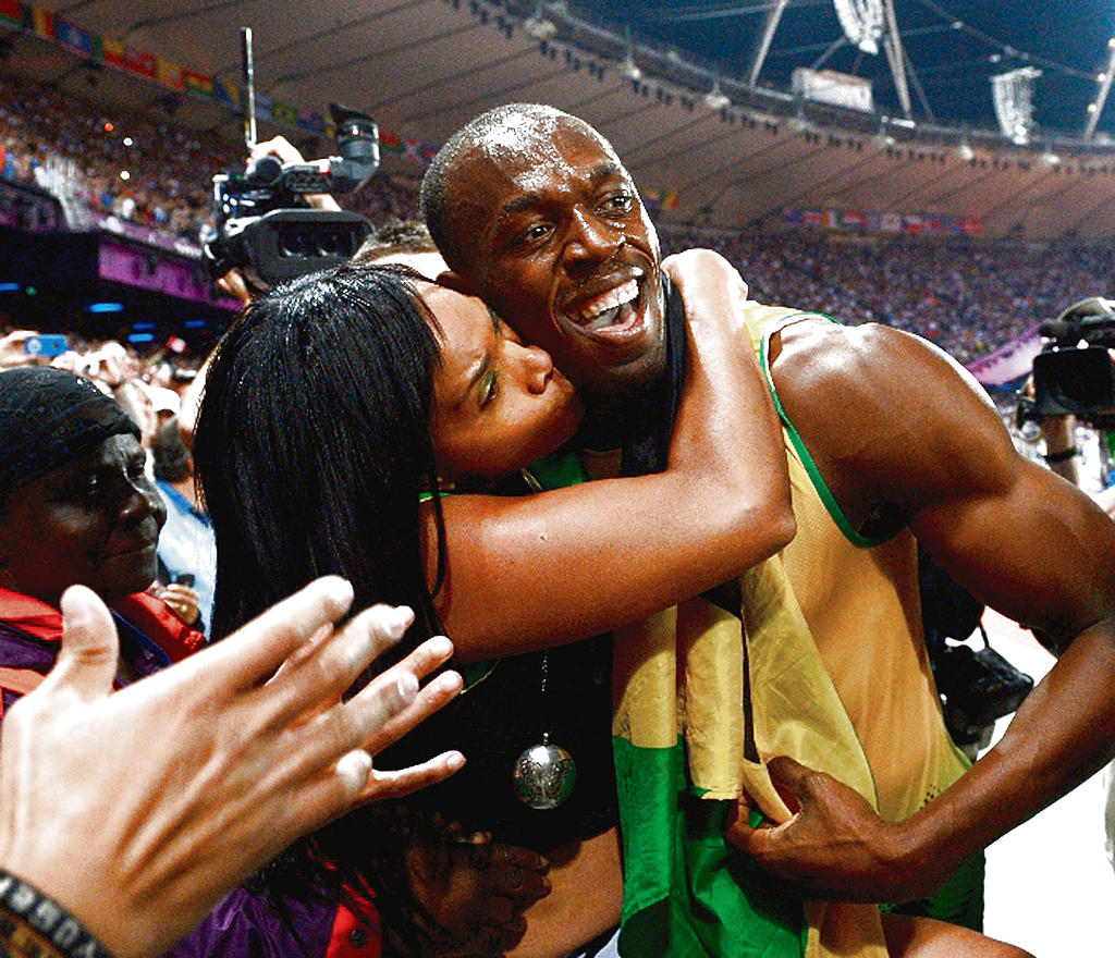 Ídolo. Usain Bolt (dcha.) celebra con una fanática.(EFE)