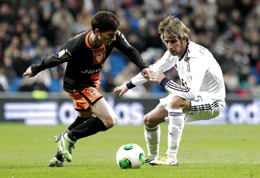 El delantero argentino del Valencia, Pablo Piatti (i), intenta superar al defensor portugués del Real Madrid, Fábio Coentrao. EFE