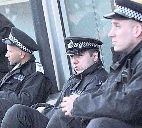 <p>Agotamiento. Un grupo de policías toma un descanso.</p>