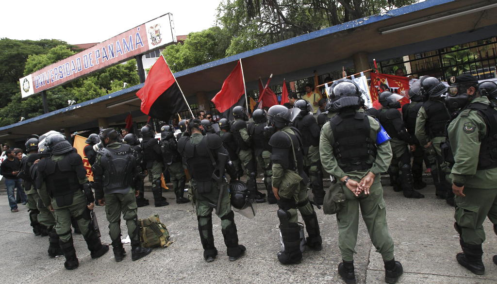 Unidades de la Policía bloquearon a los universitarios para que no cerraran la Transístmica. EFE<br>