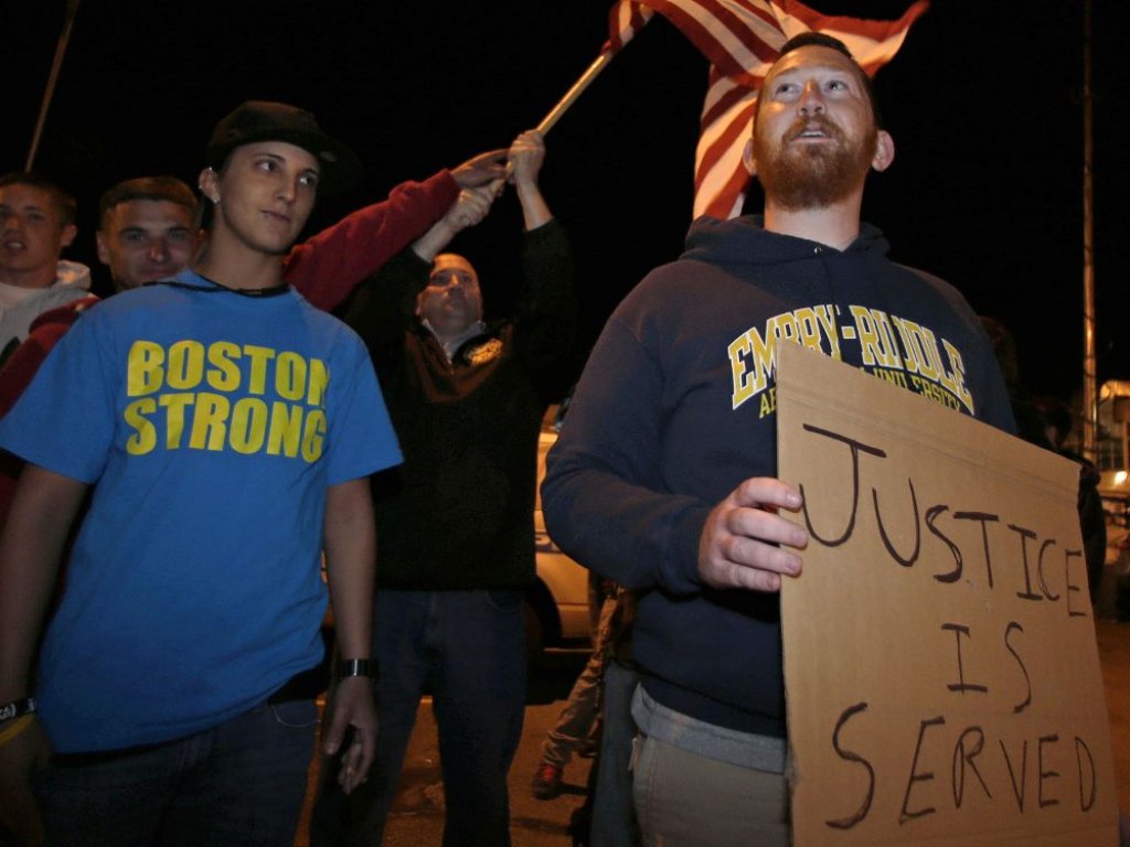 Garrett Plath, derecha, tiene un signo y Toni Zagami, izquierda, lleva una camiseta que dice: "Strong Boston" Camisa tal y como están fuera de la Dyer-Lake Funeral Home en North Attleborough, Mass, cuando un vehículo que se cree transportaba el