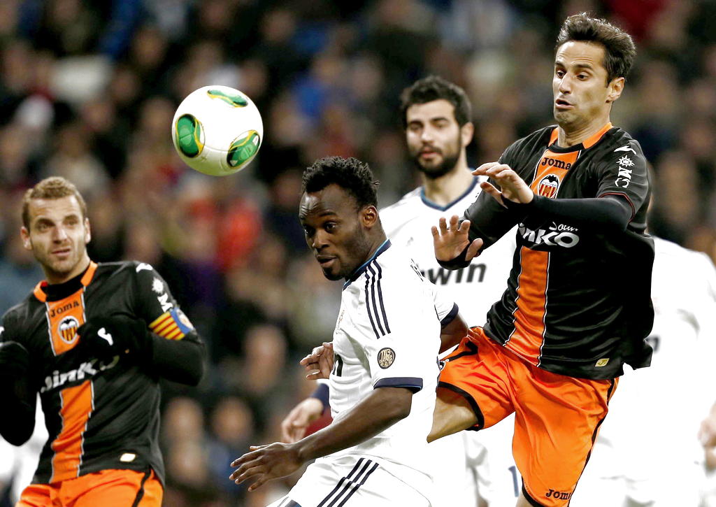 El centrocampista ghanés del Real Madrid Michael Essien (c) disputa el balón con el defensa portugués del Valencia Jonas Gonçalves (d) . EFE<br>