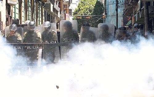 <p>Policías se protegen de las explosiones de dinamita.</p>