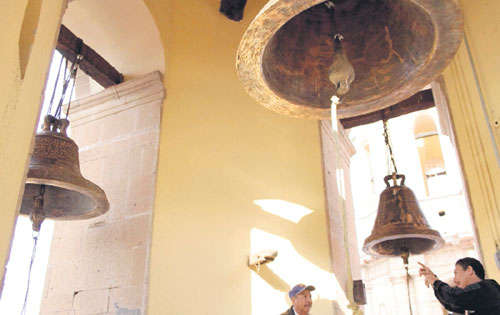 <p>Dos hombres trabajan en las campanas de la iglesia de León (México), dispuestas para la visita papal.</p>