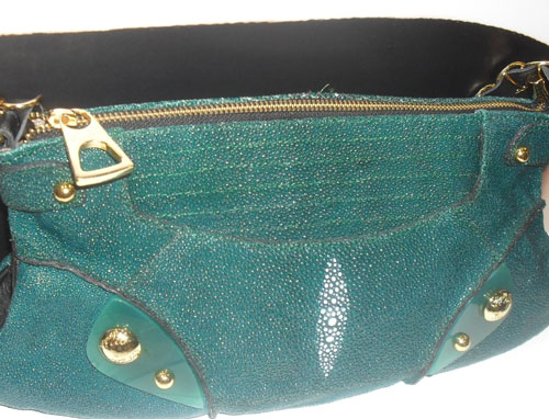 <p>Otra opción es esta en cuero de mantarraya en turquesa, también de tiras, con tachuelas en dorado; un diseño que combina con todo.</p>