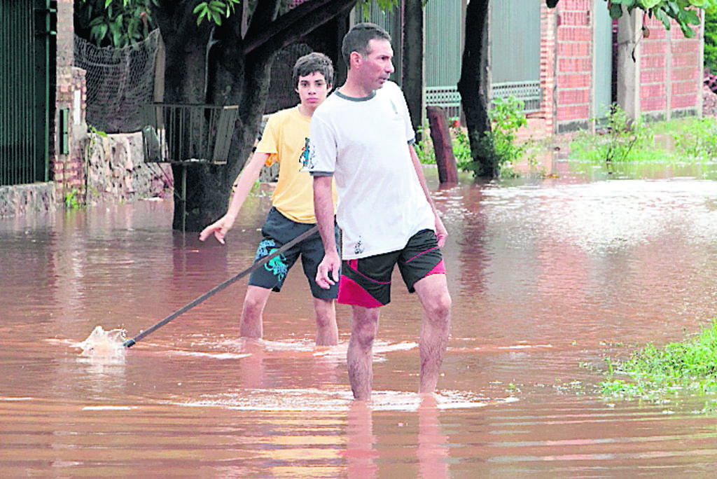Pérdida. Unos jóvenes ven cómo se inunda su casa.(EFE)