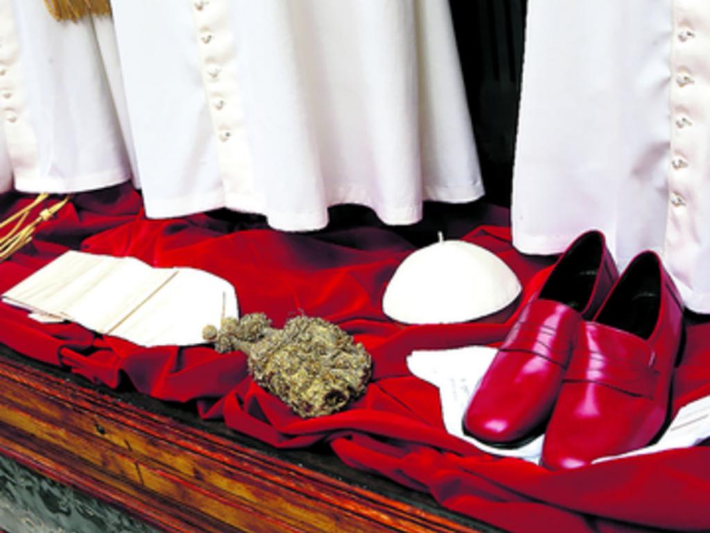 Zapatos rojos de piel y un solideo blanco expuestos en Gammarelli.(AP)