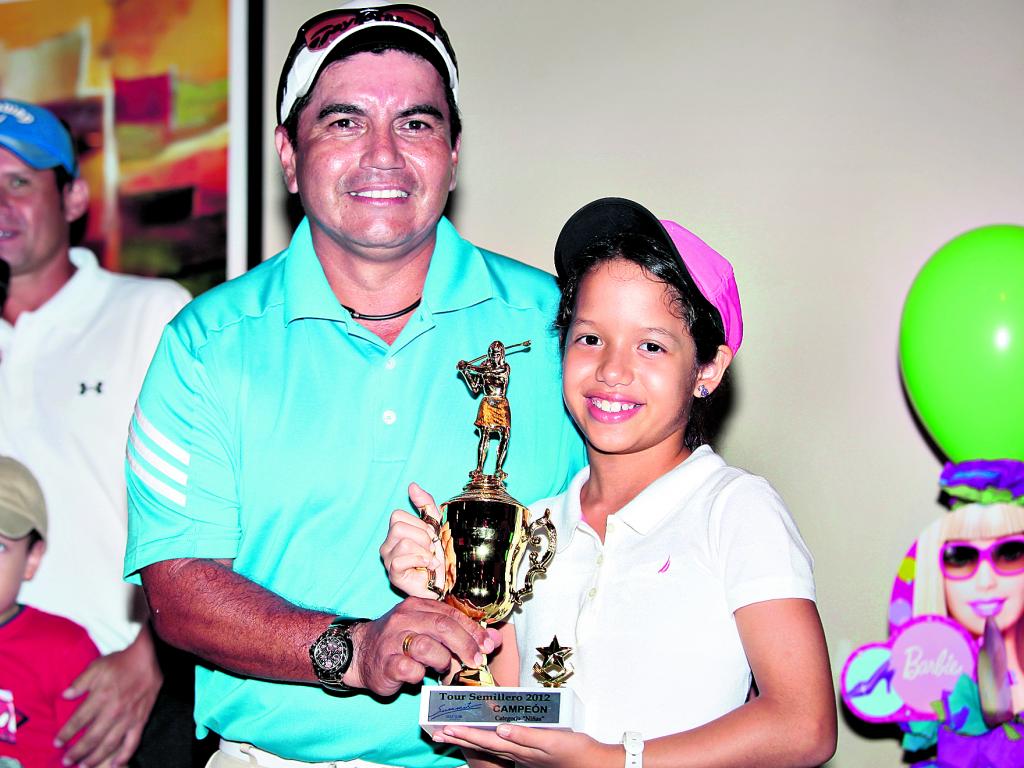 Nicole Stuart (d), recibe el premio de campeona de damas por el profesional Jorge Rodríguez.()