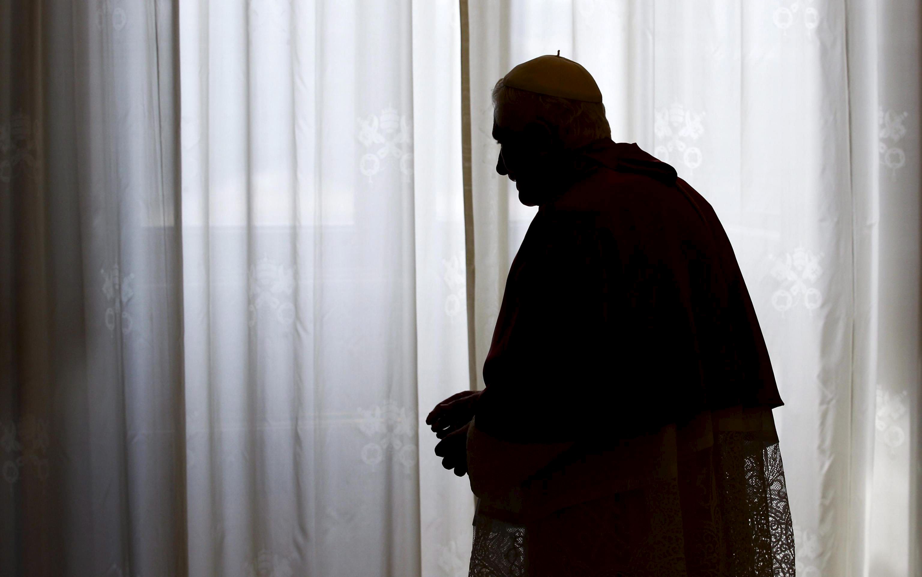 La silueta del papa Benedicto XVI frente a una ventana de la biblioteca papal. Foto/EFE<br>