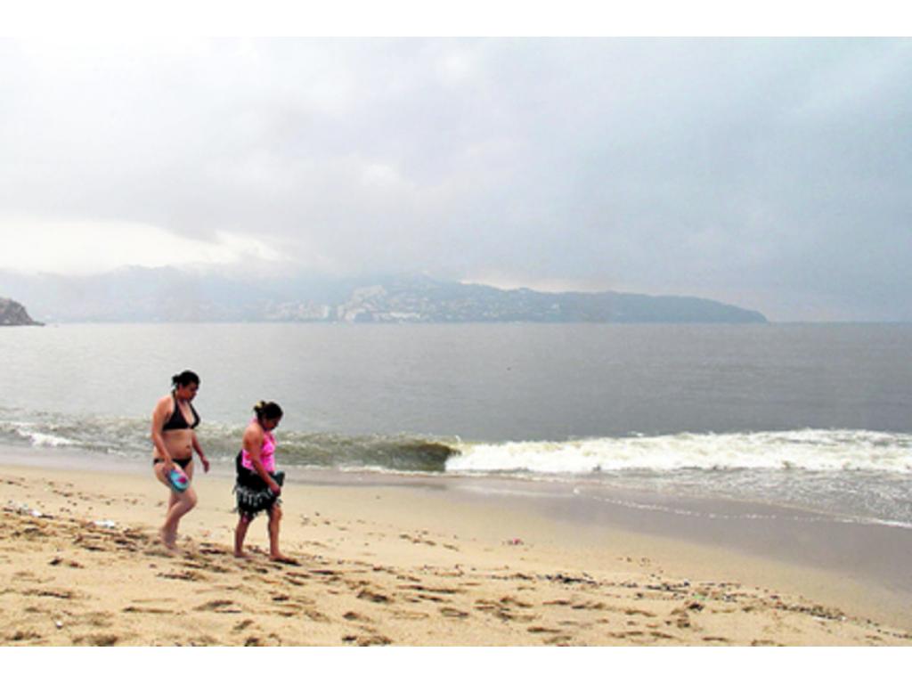 Dos mujeres caminan por la playa en Acapulco.(EFE)